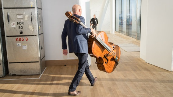 Kontrabassist Michael Rieber trägt sein Instrument in das Stimmzimmer in der Elbphilharmonie © NDR Foto: Axel Herzig