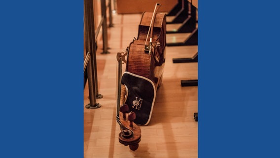 Cello liegt auf der Seite, daran ein Decker mit St.-Pauli-Logo. © NDR 