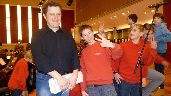 Probenszene für die Familienkonzerte: Dirigent Dave Claessen mit Mitgliedern des Knabenchors St. Nikolai im Rolf-Liebermann-Studio. © NDR Sinfonieorchester/Daniel Tomann 