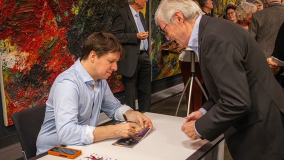 Solist Joshua Bell signiert eine CD © NDR Foto: Daniel Tomann-Eickhoff