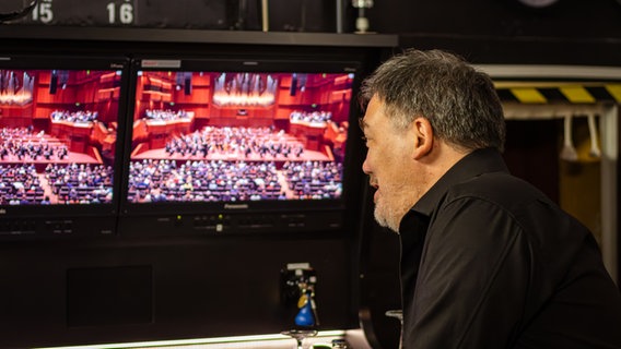 Alan Gilbert schaut auf den Übertragungsbildschirm im Backstagebereich der Alten Oper Frankfurt. © NDR Foto: Daniel Tomann-Eickhoff
