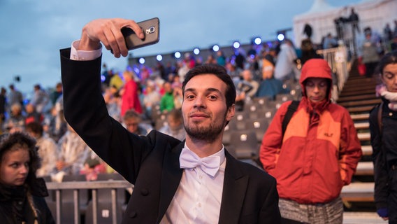 HafenCity Open Air 2016: Ein Musiker des NDR Elbphilharmonie Orchesters macht ein Selfie vor dem Publikum. © NDR Foto: Axel Herzig