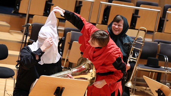 Der Hofnarr zieht dem Tubisten eine Mütze über den Kopf © NDR Foto: Marcus Krueger