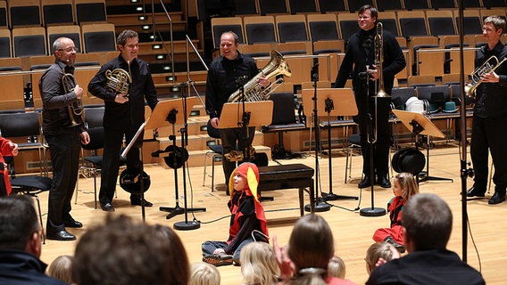 Fünf Blechbläser in schwarzer Kleidung stehen mit ihren Instrumenten auf für den Schlussapplaus. © NDR Foto: Marcus Krueger