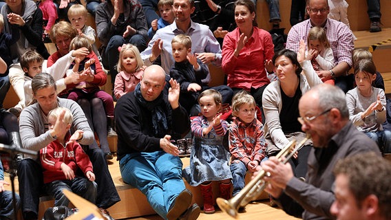 Blick aufs Publikum: Kinder und Erwachsene putzen sich imaginären Mörtel von den Händen ab. © NDR Foto: Marcus Krueger