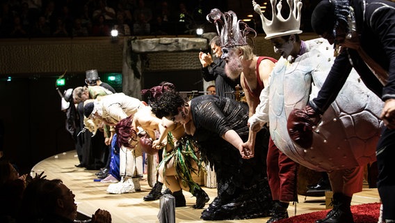 Applausszene: Bei der Premiere von Ligetis "Le Grand Macabre" in der Elbphilharmonie Hamburg verbeugen sich die Solisten auf der Bühne. Alan Gilbert applaudiert. © NDR Foto: Peter Hundert