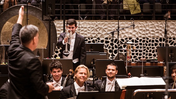 Konzertszene: Alan Gilbert lässt Solo-Trompeter Pedro Miguel Freire vom NDR Elbphilharmonie Orchester für einen Sonderapplaus aufstehen © NDR Foto: Peter Hundert