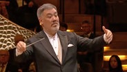 Screenshot: Chefdirigent Alan Gilbert dirigiert auf der Bühne der Elbphilharmonie beim Silvester-Konzert des NDR Elbphilharmonie Orchesters. © NDR EO Foto: Screenshot
