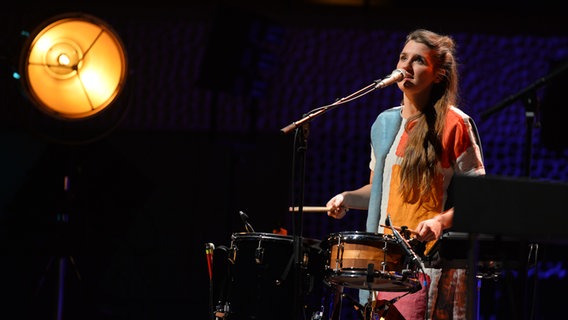 Konzertszene: Josepha Carl aus dem Pop-Duo JOCO singend und Schlagzeug spielend auf der Bühne der Elbphilharmonie. © Benjamin Hüllenkremer Foto: Benjamin Hüllenkremer