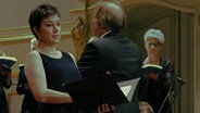 Screenshot: Solistin Sophie Harmsen steht mit dem NDR elbphilharmonie Orchester auf der Bühne. © NDR 