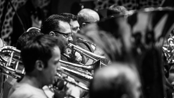 Probenszene: Die Posaunisten Uwe Leonbacher und  Simone Candotto sowie andere Musiker des NDR Elbphilharmonie Orchesters in einer Probe (Schwarz-weiß-Bild) © NDR Foto: Peter Hundert