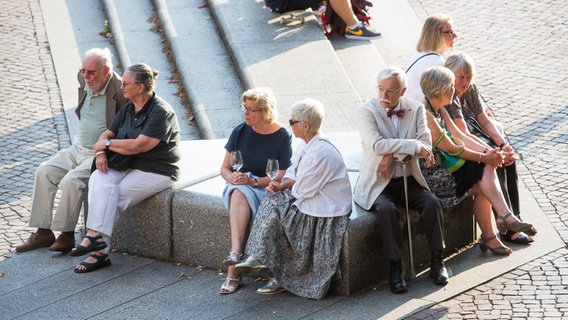 Konzertbesucher warten auf dem Johannes-Brahms-Platz vor der Laeiszhalle bei einem Glas Wein auf den Beginn der Opening Night 2016 © NDR Foto: Axel Herzig