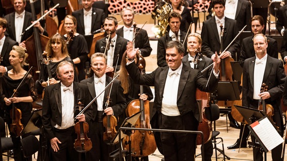 Szene aus der Opening Night 2019 des NDR Elbphilharmonie Orchesters: Alan Gilbert und das Orchester stehen für den Schlussapplaus auf der Bühne des Großen Saals der Elbphilharmonie © NDR Foto: Peter Hundert