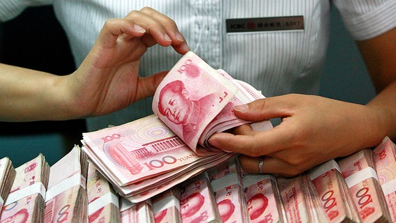 Eine chinesische Bankangestellte zählt Geldscheine. © dpa picture alliance Foto: Xie Zhengyi