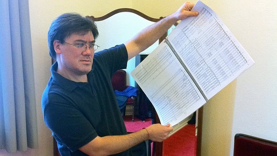 Im Dirigentenzimmer der Laeiszhalle: Alan Gilbert zeigt eine Partitur © NDR Sinfonieorchester 