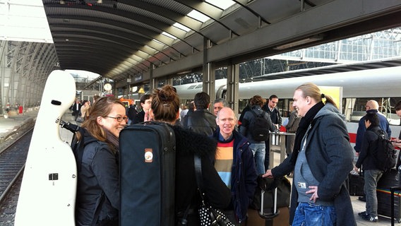 Mitglieder des NDR Sinfonieorchesters mit ihren Instrumentenkoffern auf dem Bahnsteig. © NDR Sinfonieorchester 