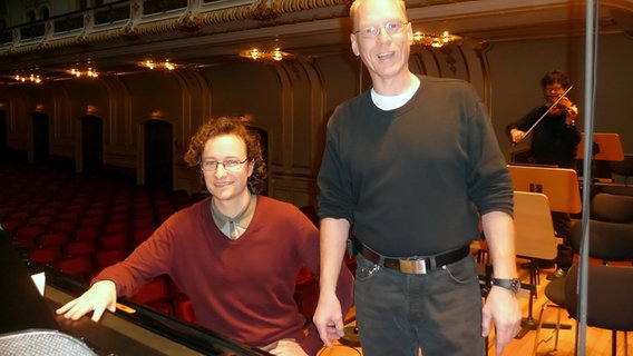 Martin Helmchen am Flügel auf der Laeiszhallen-Bühne, neben im Orchesterinspizient Wolfgang Preiß. © NDR Sinfonieorchester 