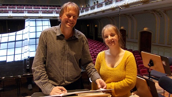 In der Probenpause: Thomas Hengelbrock und Lise de la Salle vor einem Notenständer auf der Laeiszhallen-Bühne. © NDR Sinfonieorchester 