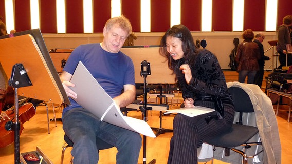 Dirigent Karl-Heinz Steffens und Sopranistin Ha Young Lee studieren eine Partitur im Rolf-Liebermann-Studio. © NDR Sinfonieorchester 