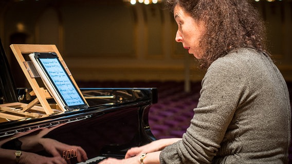 Angela Hewitt spielt am Flügel, auf dem Notenständer zeigt ein iPad die Noten an. © NDR Sinfonieorchester 