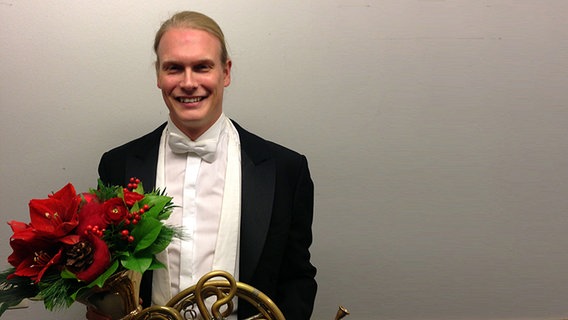 Solo-Hornist Jens Plücker nach dem Konzert mit Blumenstrauß und Horn © NDR Sinfonieorchester 