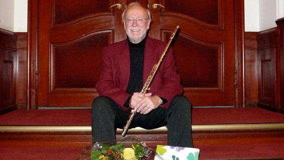 Flötist Hans-Udo Heinzmann mit seinem Instrument auf den Stufen vor einer Loge in der Laeiszhalle © NDR Sinfonieorchester 