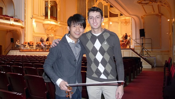 Fumiaki Miura und Narek Hakhnazaryan Arm in Arm im Zuschauerraum der Laeiszhalle © NDR 