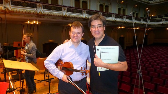 Probenpause: Frank Peter Zimmermann und Alan Gilbert Arm in Arm auf der Bühne der Laeiszhalle © NDR 