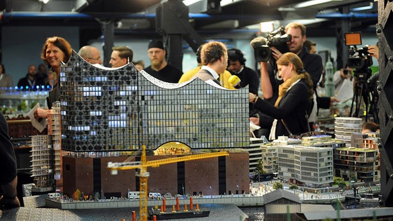 Das Miniatur-Modell der Elbphilharmonie im Miniatur Wunderland. Im Hintergrund jede Menge Journalisten mit Mikrofonen und Kameras. © NDR Foto: Markus Hötzel