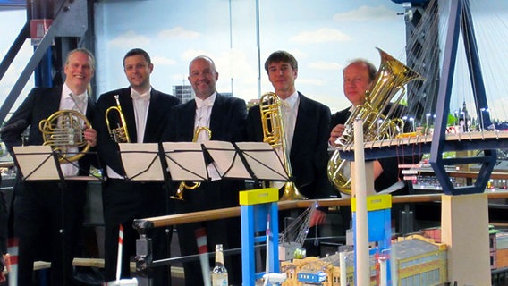 Blechbläser des NDR Sinfonieorchesters warten mitten im Miniatur Wunderland auf ihren Einsatz. © NDR 