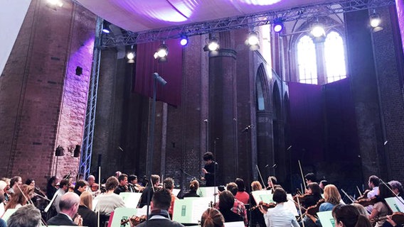 Rafael Payare dirigiert das NDR Sinfonieorchester auf der Bühne der Konzertkirche Wismar St. Georgen.  