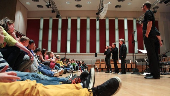 Streicher des NDR Sinfonieorchesters sprechen bei einer Schulveranstaltung im Rolf-Liebermann-Studio mit Jugendlichen.  