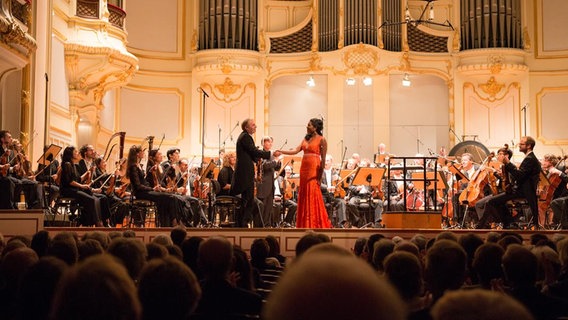 Roland Greutter gratuliert Mezzosopranistin J'nai Bridges auf der Bühne  