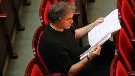Komponist Thierry Escaich blättert in Noten. © NDR Sinfonieorchester 