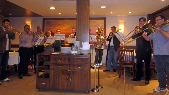 Die Musiker von NDR Brass spielen in einem Restaurant eine Fanfare © NDR SO 