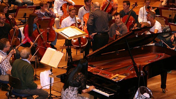 Probenszene: Musiker des NDR Sinfonieorchesters mit Dirigent Arvo Volmer und Pianistin Hyun-Jung Lim am Flügel © NDR SO 