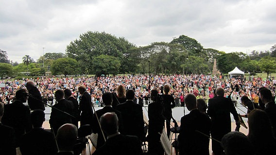 Blick über die Orchestermusiker ins applaudierende Publikum beim Open Air-Konzert im Ibirapuera-Park © NDR SO 