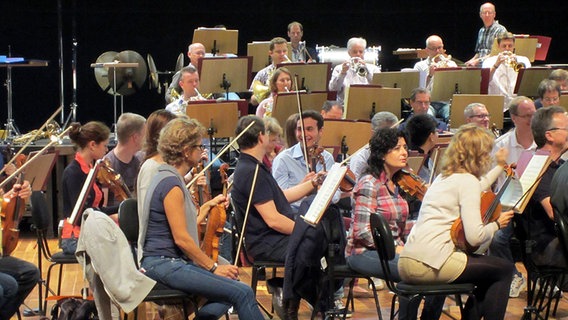 Probenszene: Orchestermusiker sitzen hinter Notenständern © NDR SO 