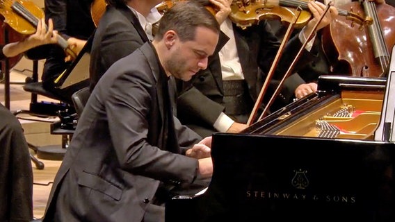 Screenshot: Pianist Francesco Piemontesi spielt mit dem NDR Elbphilharmonie Orchester in der Elbphilharmonie. Am Pult: Aivis Greters. © NDR Foto: Screensot