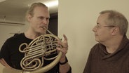 Screenshot: Solo-Hornist Jens Plücker und Dirigent Stefan Asbury während einer Probe © NDR 