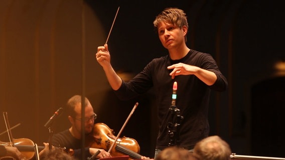 Screenshot: Krzysztof Urbański dirigiert in der Probe mit dem NDR Sinfonieorchester © NDR 