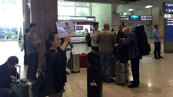 Eine Koreanerin wartet mit einem NDR-Schild in der Hand am Flughafen in Seoul auf die Musiker des NDR Sinfonieorchesters Eine Koreanerin wartet mit einem NDR-Schild in der Hand am Flughafen in Seoul auf die Musiker des NDR Sinfonieorchesters