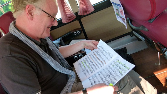 Radboud Oomens mit Noten im Bus © NDR Sinfonieorchester 