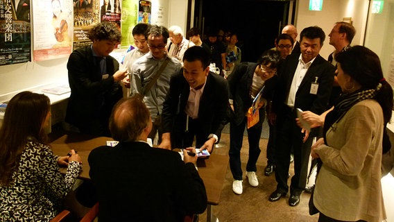 Konzertbesucher in Osaka stehen Schlange für ein Autogramm von Arabella Steinbacher und Thomas Hengelbrock  