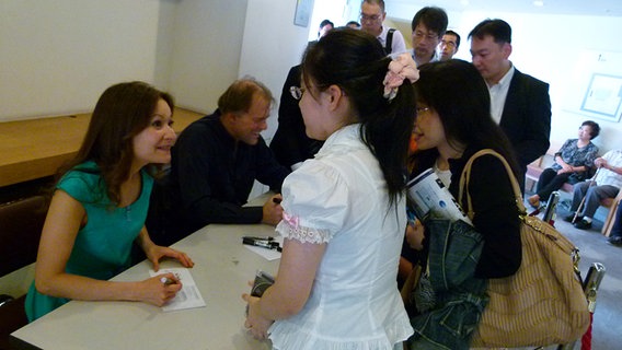 Arabella Steinbacher und Thomas Hengelbrock schreiben Autogramme für japanische Konzertbesucher  