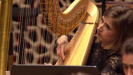 Screenshot: Anaëlle Tourret, Solo-Harfenistin des NDR Elbphilharmonie Orchester beim Konzert. © NDR/Screenshot 