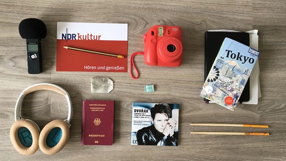 Mikrofon, NDR Kultur Block mit Bleistift, Kamera, Tokyo-Reiseführer, Kopfhörer, Reisepass, CD und Stäbchen liegen bereit. © NDR Foto: Anna Novák