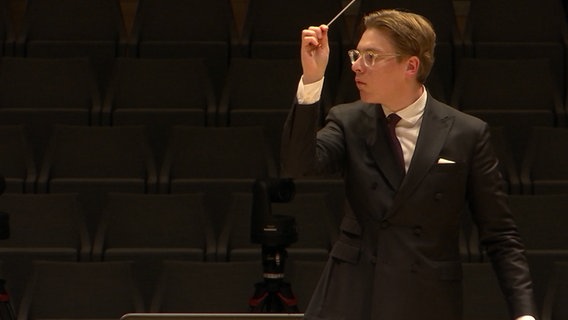 Screen capture: conductor Klaus Makela conducts.  © NDR Photo: screenshot