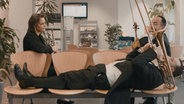 Mitglieder des NDR Elbphilharmonie Orchesters sitzen und liegen mit ihren Instrumenten auf Stühlen. © NDR 