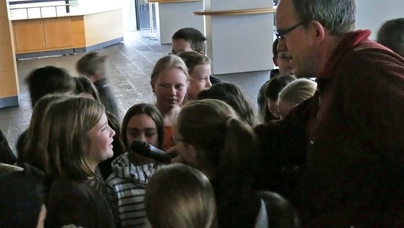 NDR Redakteur Jörgpeter von Clarenau (rechts) befragt Kinder nach der Generalprobe zum Orchesterhörspiel "A Christmas Carol" über ihre Eindrücke,  20.12.2012 © NDR Foto: Wolf-Rüdiger Leister